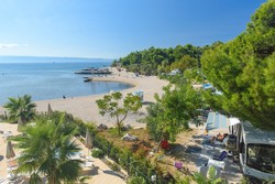 Glavna plaža je prodnata, tik nad njo so zunanji bazeni in najboljše parcele.